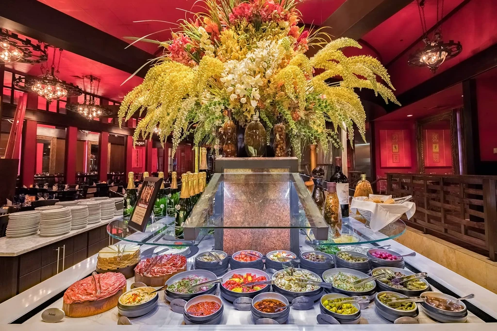 Opulent cold buffet with flowers in a luxurious red restaurant.