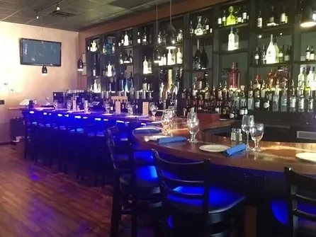 Empty bar with blue LED lighting on counter and bottle display.