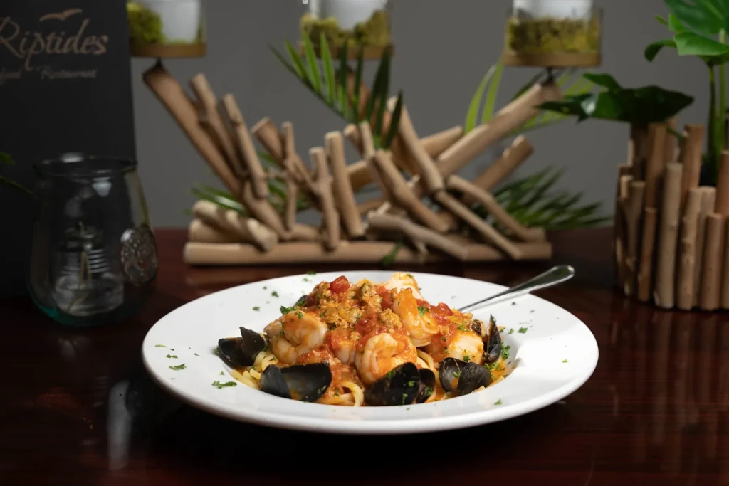 Close-up of seafood linguine with shrimp, mussels, and tomato sauce.