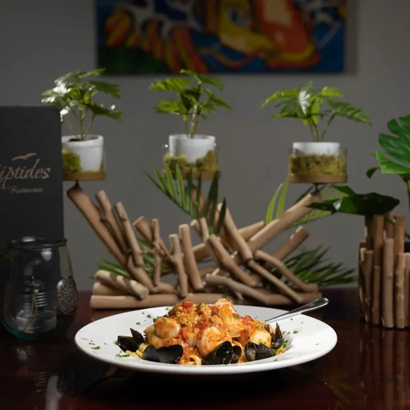 Close-up of pasta with shrimp and mussels on a restaurant table.