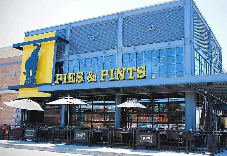 Modern Pies & Pints restaurant exterior with elephant sign and patio.
