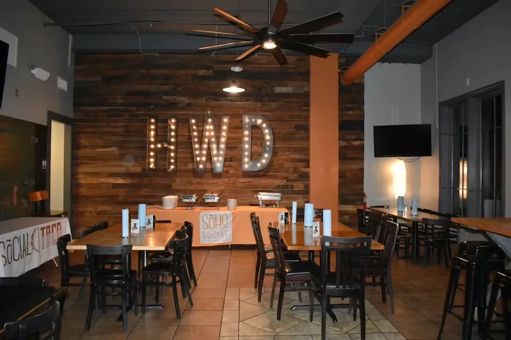 Industrial restaurant space featuring HWD marquee letters and a buffet line.
