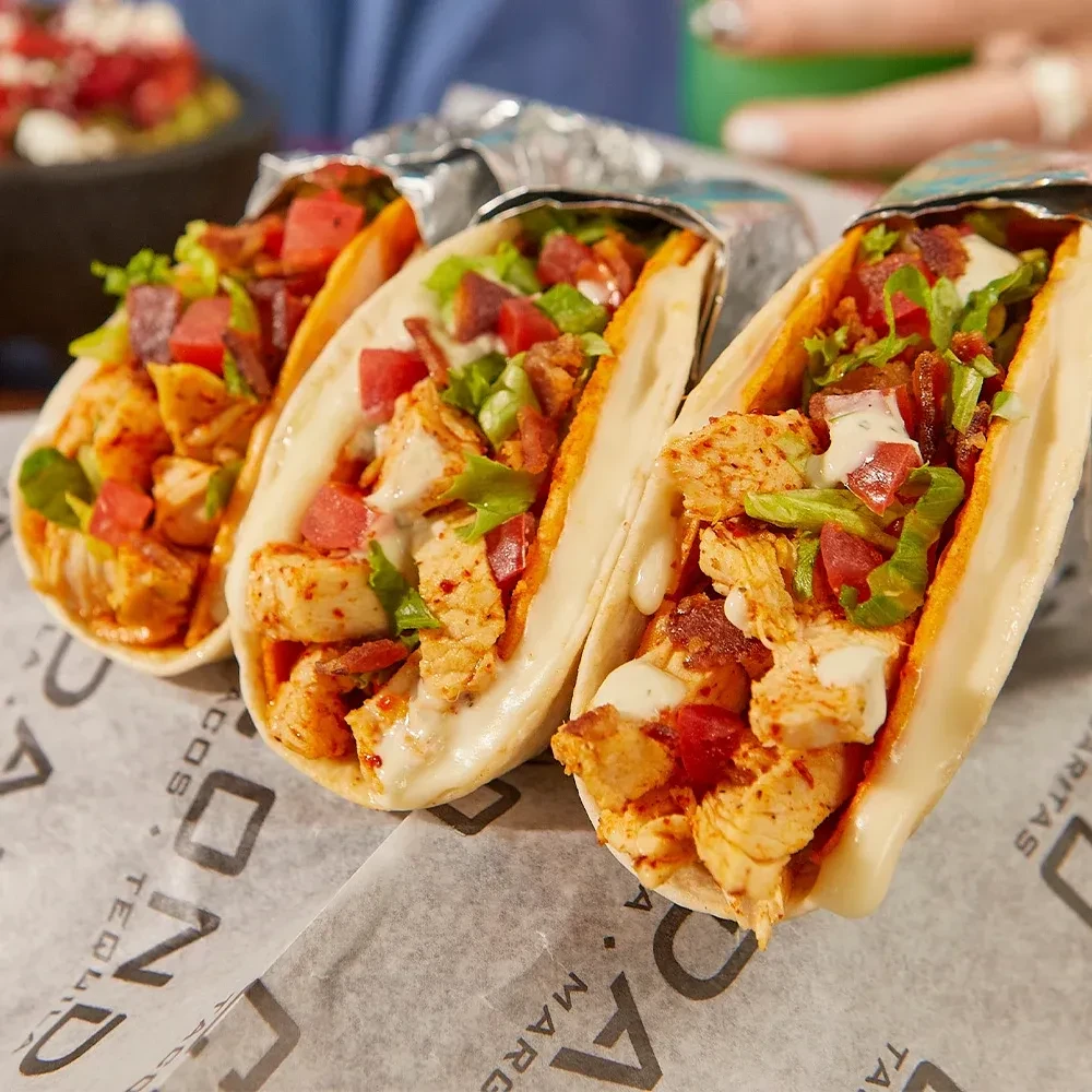 Three soft tacos with chicken, tomato, lettuce, bacon, and creamy sauce.
