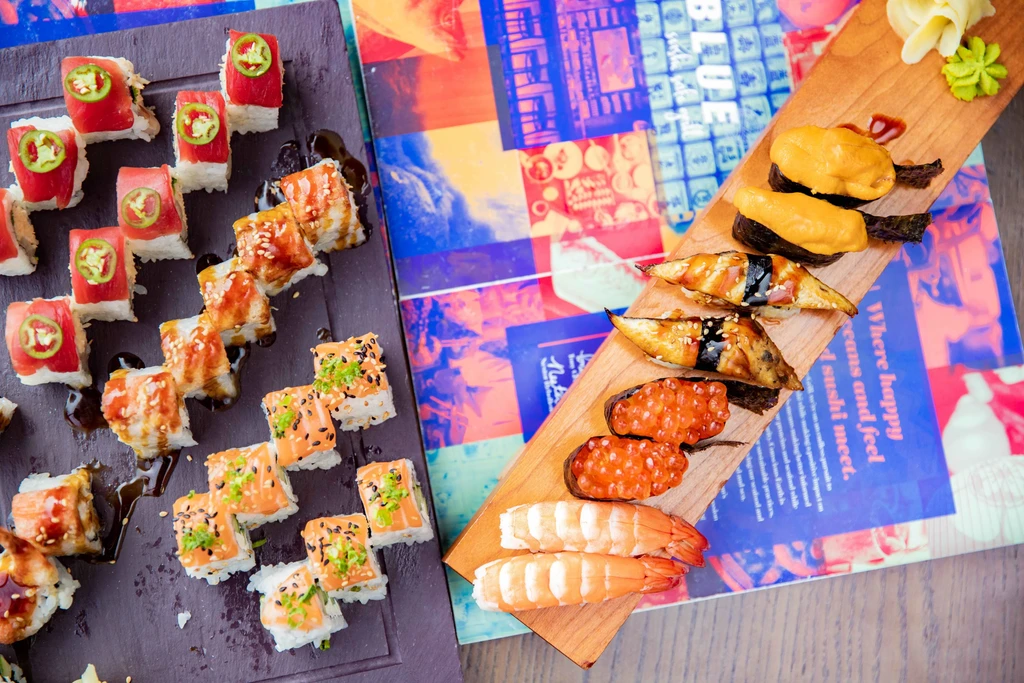 Vibrant overhead display of various sushi, sashimi, and nigiri platters.