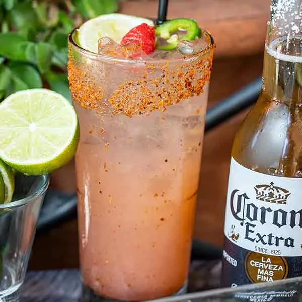 Spiced cocktail with lime, raspberry, jalapeño, and Corona Extra beer.