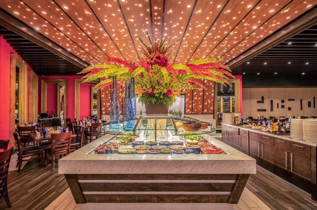 High-end restaurant buffet with colorful food, starry ceiling, and ornate mirrors.