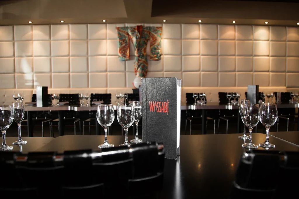 Modern Wassabi restaurant bar with empty glasses, padded wall, and kimono.