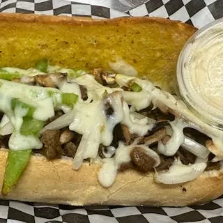 Cheesesteak sub with beef, melted cheese, onions, peppers, and creamy sauce.