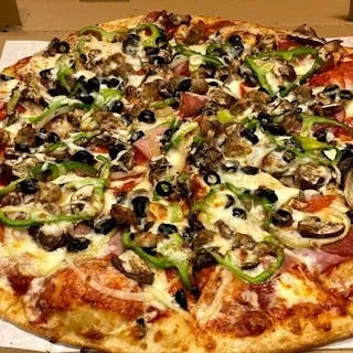 Pizza with various meats, vegetables, and melted cheese in a box.