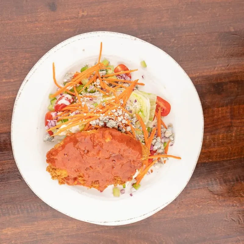 Buffalo chicken salad with blue cheese on a wooden table.