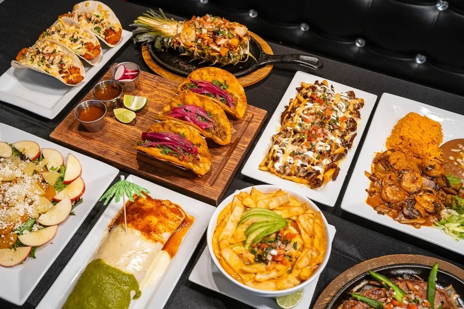 Vibrant array of Mexican and Latin American dishes on a dark table.