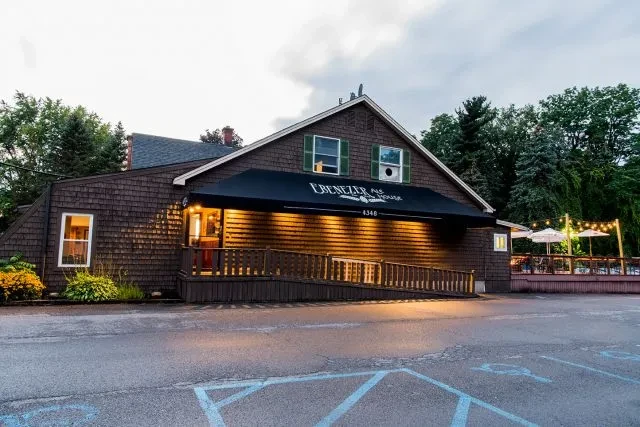 Ebenezer Ale House exterior with awning, warm lights, accessibility ramp, patio.