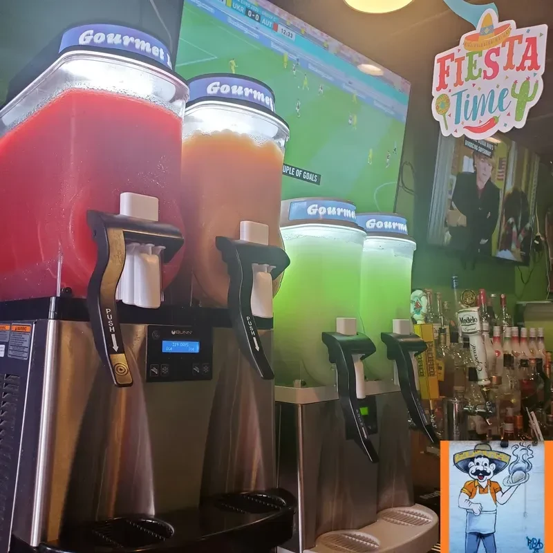 Four colorful slushie machines inside a Mexican-themed bar.