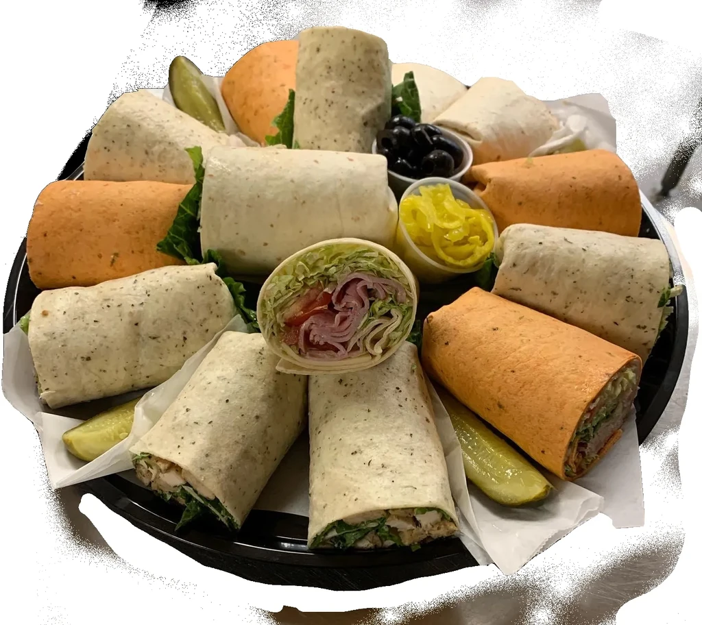 Circular platter of various deli meat wraps, pickles, olives, and peppers.