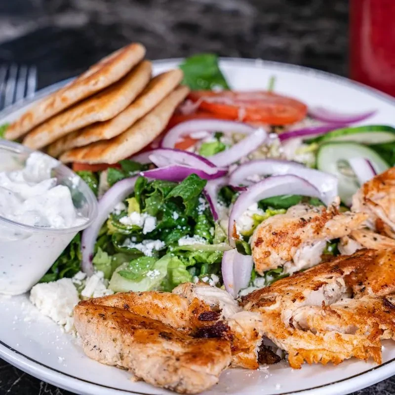 Grilled chicken Greek salad with feta, pita, and creamy dressing.