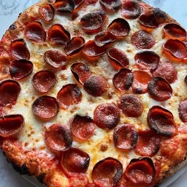 Whole pepperoni pizza with melted cheese, bubbly crust, and crisped pepperoni.