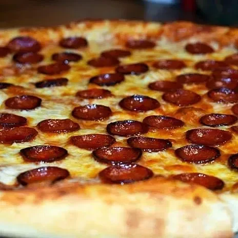 Close-up: Freshly baked pepperoni pizza with bubbly cheese and glistening pepperoni.