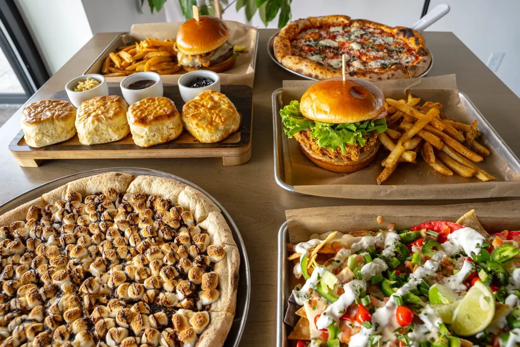 Overhead view of diverse savory and sweet dishes on a restaurant table.