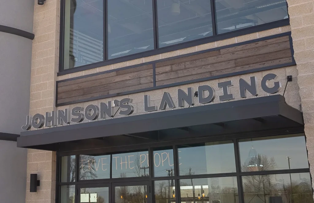 Modern building exterior, Johnson's Landing sign above glass entrance.