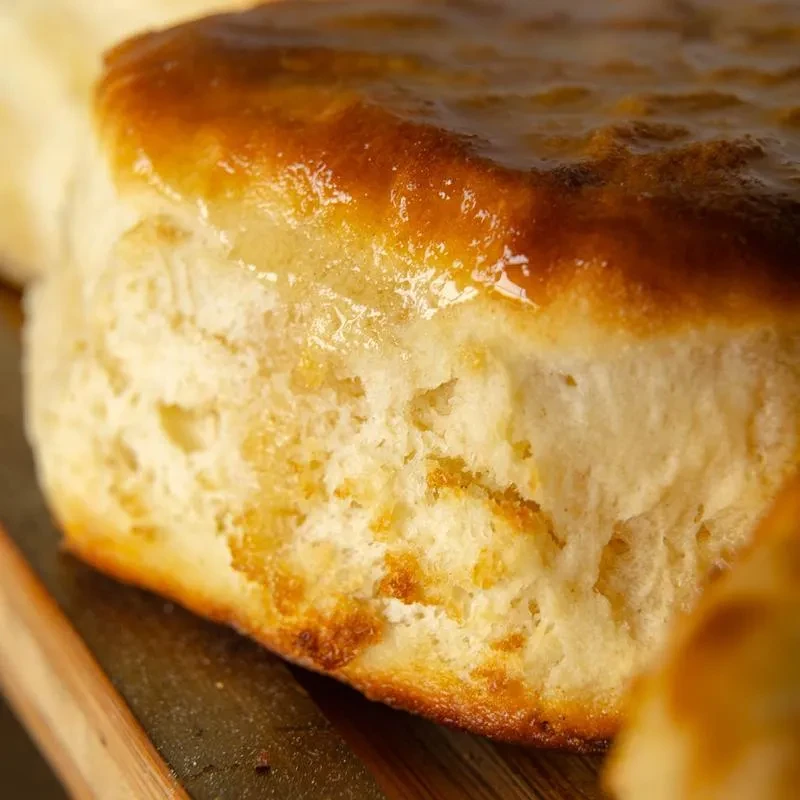 Close-up of a golden-brown biscuit with a glistening, glazed top.