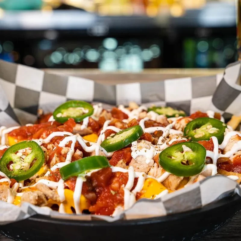 Loaded nachos or fries topped with cheese, salsa, chicken, jalapeños.