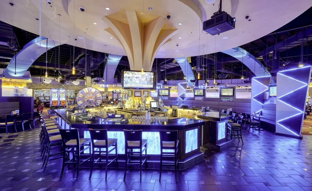 Empty casino bar illuminated by purple and blue LED lights.