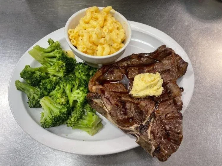 Grilled T-bone steak, broccoli, and mac and cheese meal.