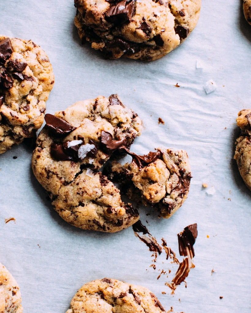 Broken chocolate chip cookie with melted chocolate and sea salt.