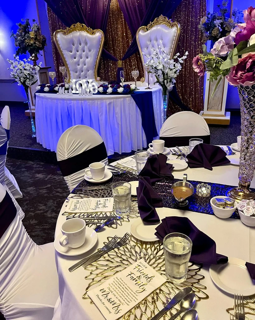 Elaborate wedding reception with gold, purple, blue, and throne chairs.