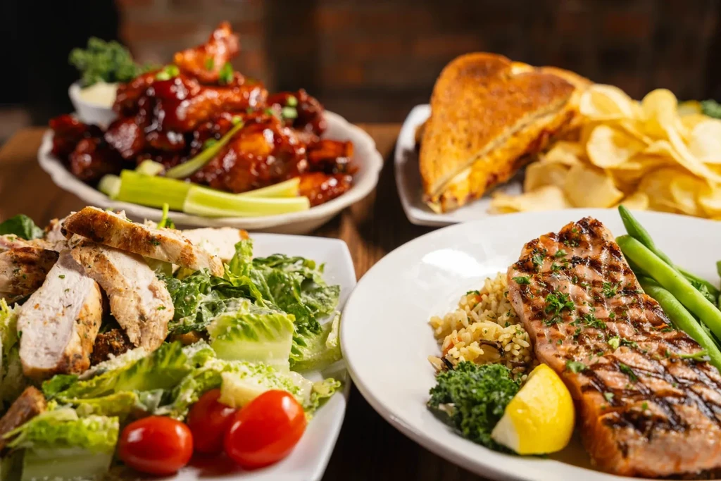Caesar salad, grilled salmon, buffalo wings, and grilled cheese sandwich.