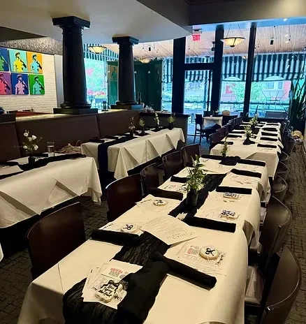 Restaurant dining area with tables set for an event, personalized favors.