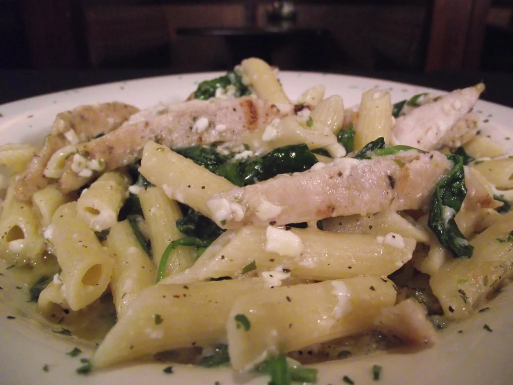 Penne pasta with chicken, spinach, crumbled white cheese, creamy sauce.