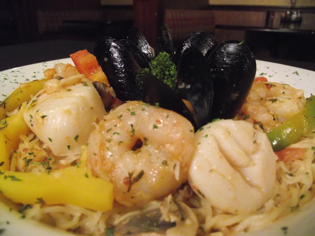 Vibrant seafood pasta with mussels, shrimp, scallops, and colorful vegetables.