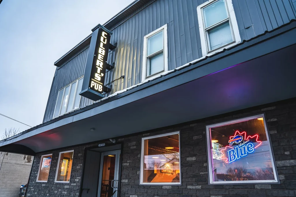 Dark grey Culbert's Pub exterior with snow and Labatt Blue sign.