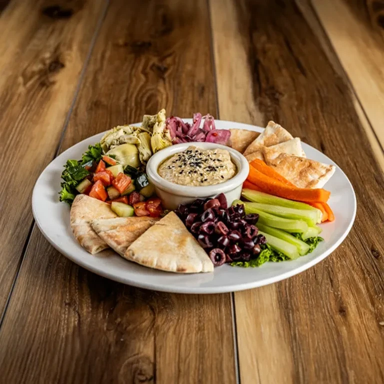 Platter of hummus, pita, olives, vegetables, and marinated artichokes.