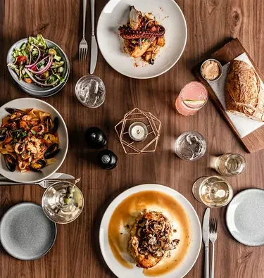Flat lay: sophisticated dining table with gourmet food and drinks.