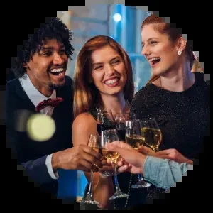 Three smiling people clinking wine glasses in a festive toast.