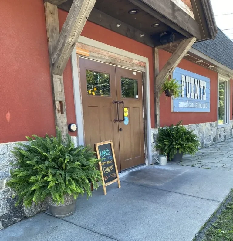 PUENTE American-Latino pub, stucco and stone exterior with ferns.