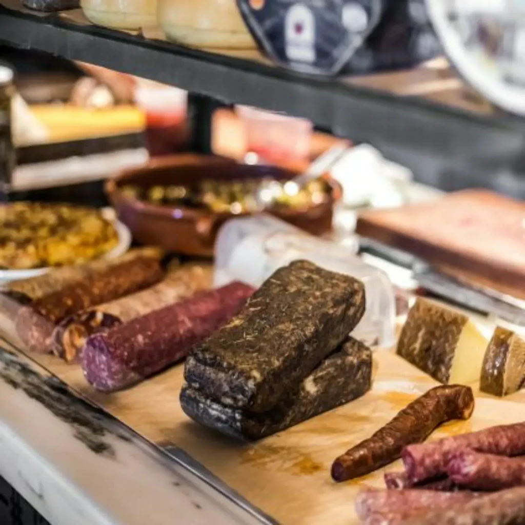 Deli display featuring cured sausages and artisanal cheeses.