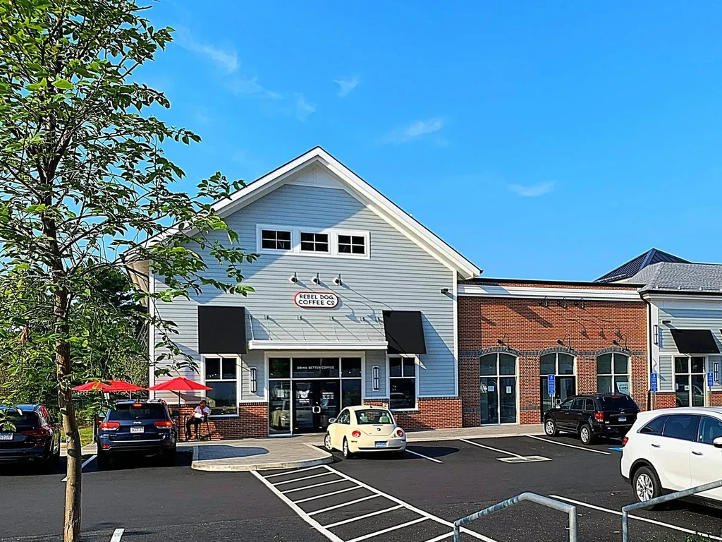 Sunny Rebel Dog Coffee Co. building, light blue-gray, with outdoor seating.