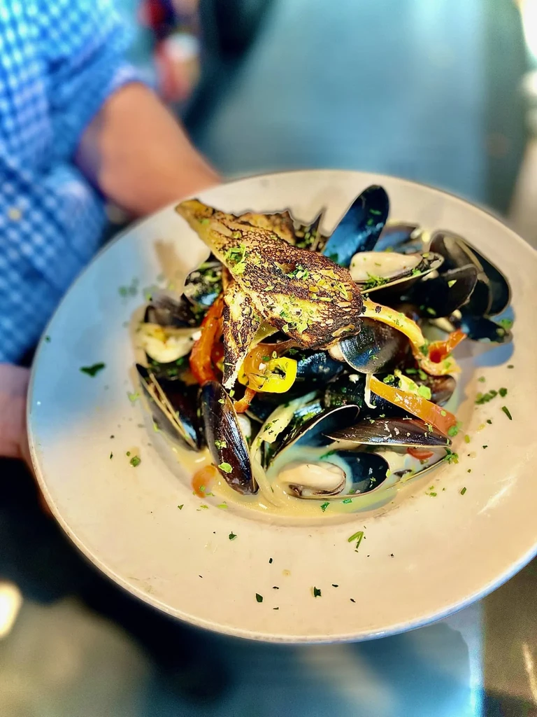 Steamed mussels in creamy sauce with herbs and roasted artichoke hearts.