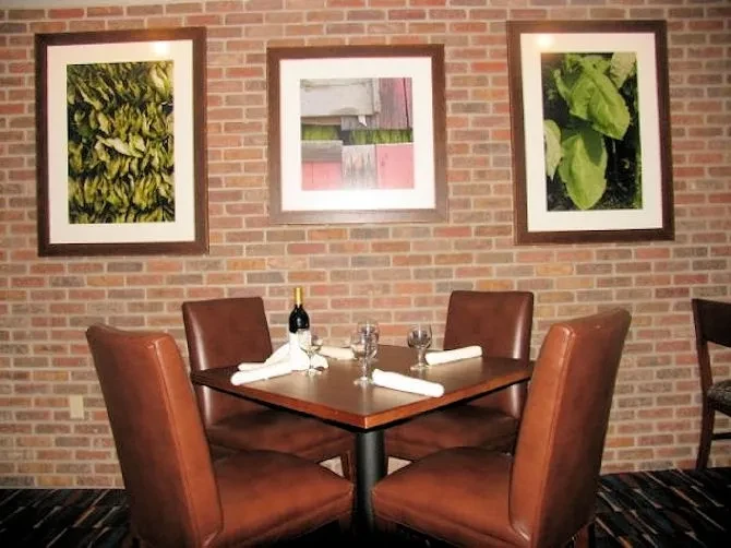 Rustic restaurant interior with brick walls and table set for four.