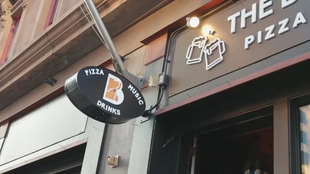 Two prominent restaurant signs on an older building facade.