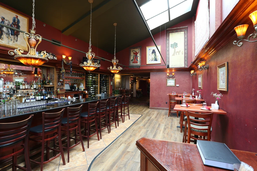 Elegant restaurant interior with a detailed bar and empty dining area.