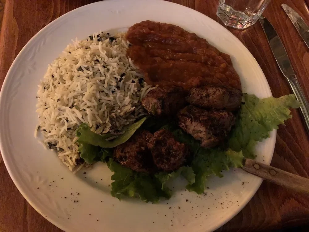Overhead: basmati rice, grilled meat on lettuce, and reddish stew.