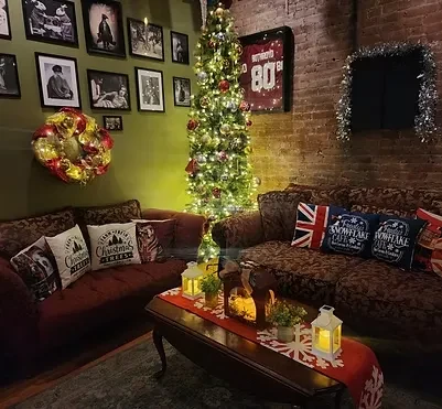 Cozy Christmas-decorated lounge with sofas, coffee table, and lit tree.