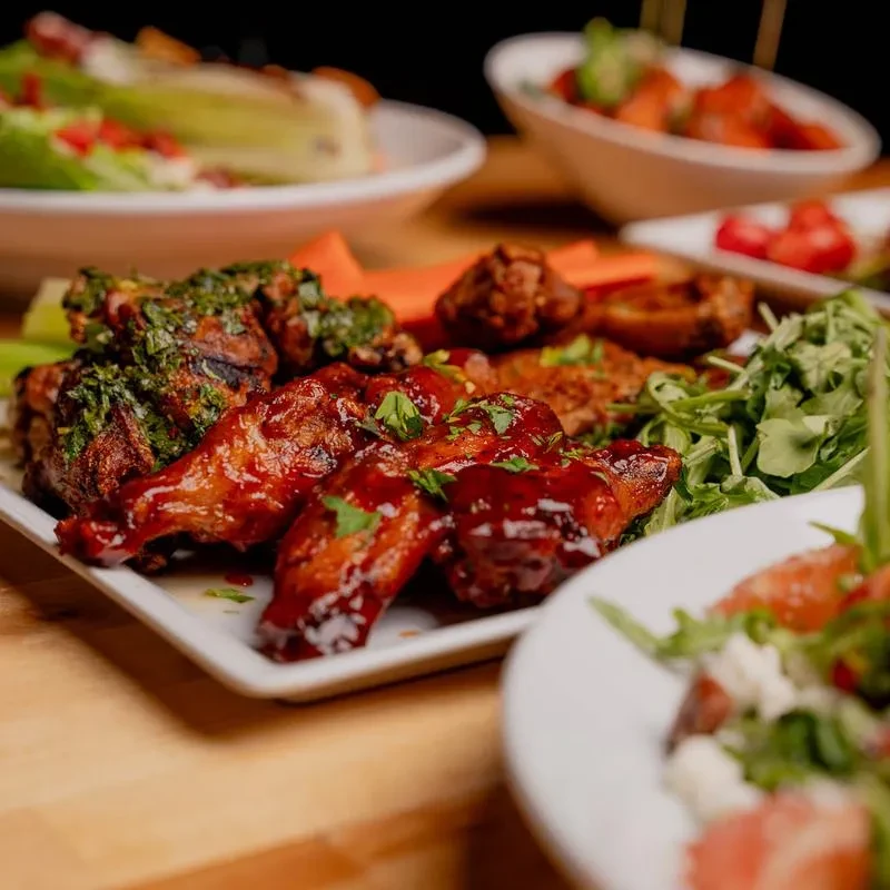Rectangular platter of varied chicken wings, carrots, and celery.