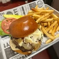 Close-up of a burger and crispy golden fries on a decorative tray.