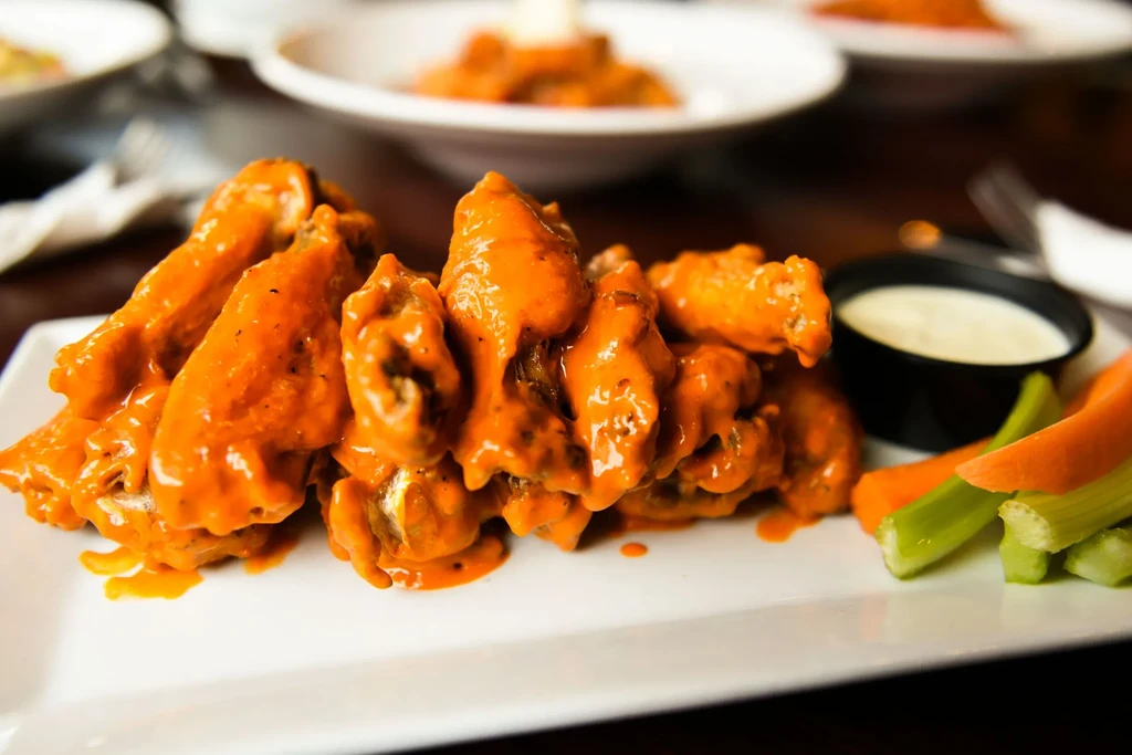 Piled, saucy Buffalo wings with creamy dip, celery, and carrots.