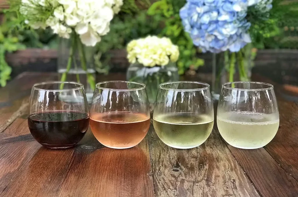 Chilled wines in stemless glasses with a blurred floral background.